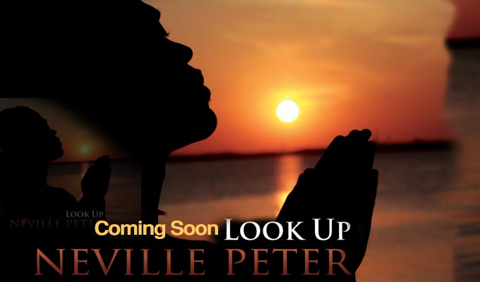 Neville praying with hands folded an head tilted back against a back ground of ocean and sky.