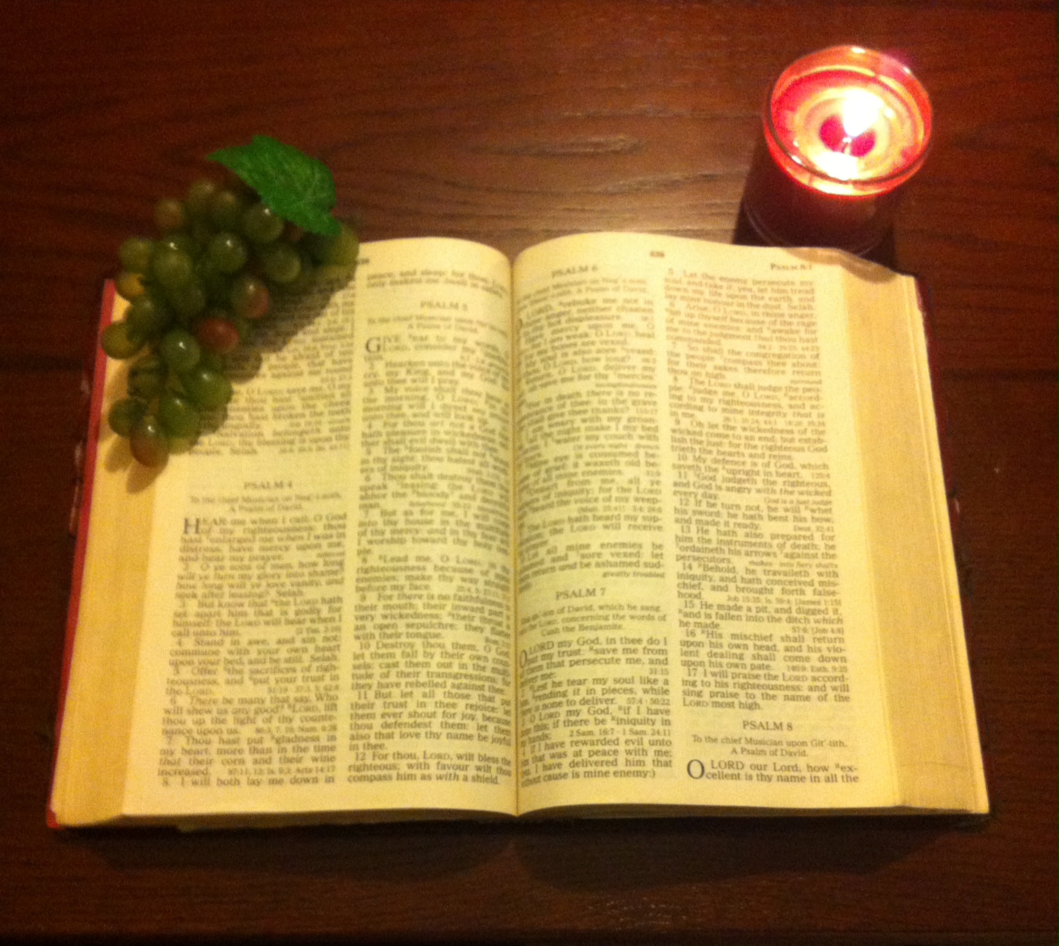 Open bible with the light of a Candle shining on it's pages